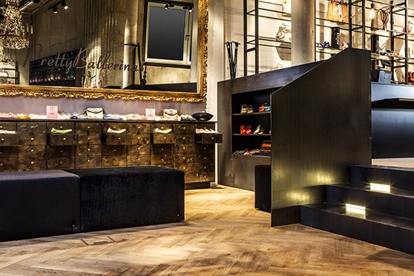 Обувной магазин Bespoke, Мюнхен – роскошное зеркало создает неповторимую атмосферу, контрастируя своей позолоченной рамой с бетонными стенами и лаконичными черными стеллажами