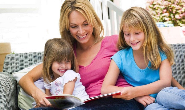 На фото – мама с детьми читают книгу